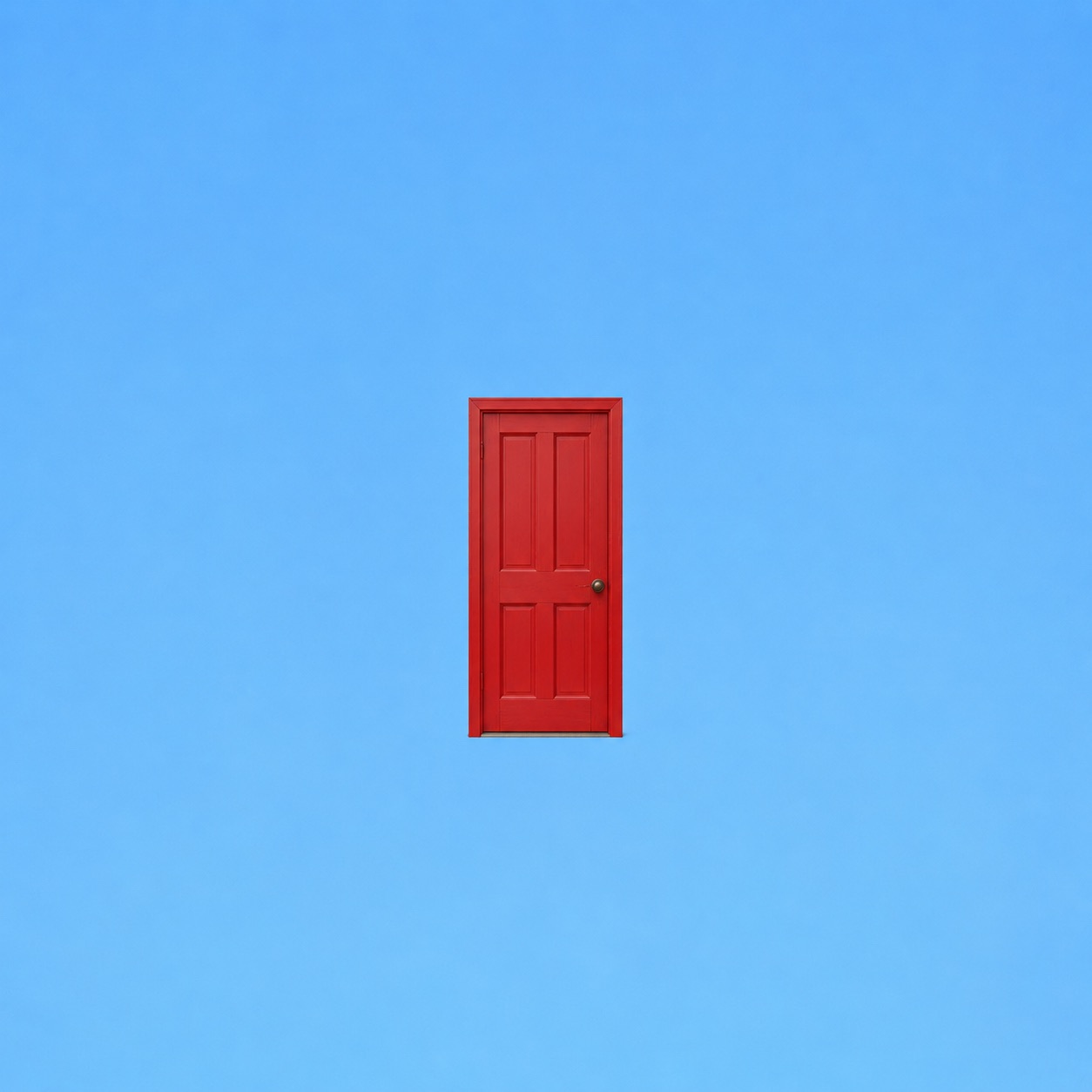A red door in a bright blue sky